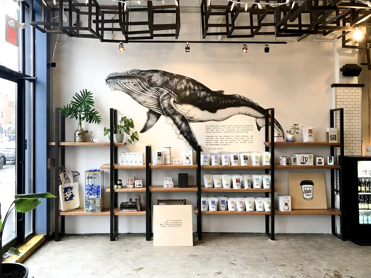 Illustration of a swiming whale printed on a storefront wall
